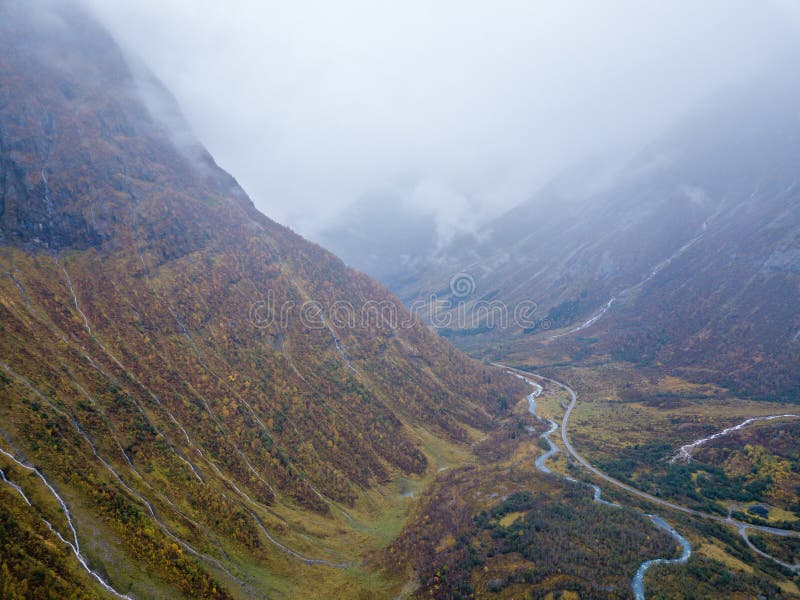 Foto del abejón de varias pequeñas cascadas en montañas con las nubes que las cubren cerca del glaciar de Bøjabreen en Noruega imágenes de archivo libres de regalías Foto del abejón de varias pequeñas cascadas en montañas con las nubes que las cubren cerca del glaciar de Bøjabreen en Noruega imágenes de archivo libres de regalías