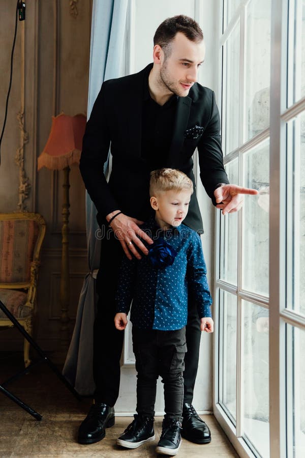 Foto del hombre feliz y su del hijo que se sientan por la ventana fotografía de archivo Foto del hombre feliz y su del hijo que se sientan por la ventana fotografía de archivo