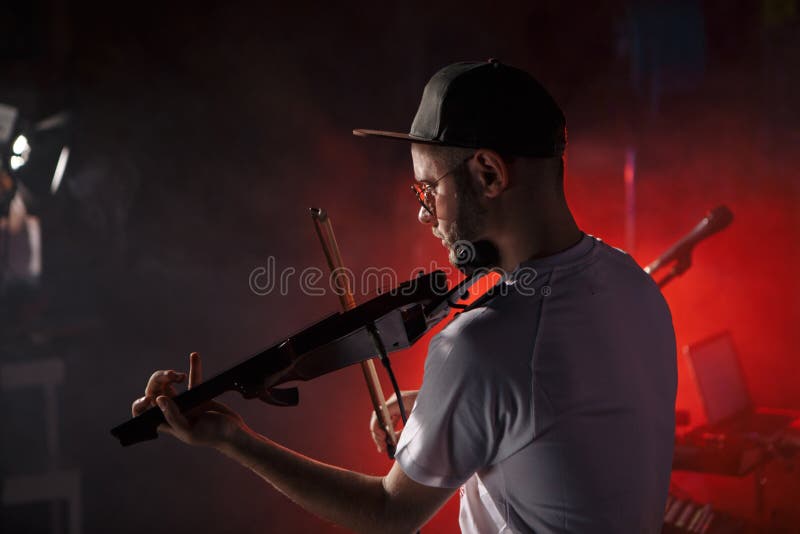 Foto del primer del hombre que toca el violín eléctrico fotos de archivo libres de regalías Foto del primer del hombre que toca el violín eléctrico fotos de archivo libres de regalías