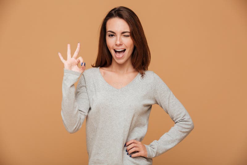 Foto del primo piano di giovane donna castana divertente nella manifestazione grigia della blusa fotografia stock libera da diritti Foto del primo piano di giovane donna castana divertente nella manifestazione grigia della blusa fotografia stock libera da diritti