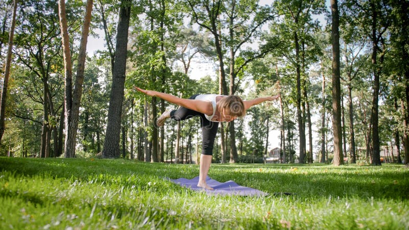 Foto der l?chelnden Frau Yoga- und Eignungs?bungen tuend Mittlere gealterte Leute, die um ihrer Gesundheit sich k?mmern Harmonie stockbild Foto der l?chelnden Frau Yoga- und Eignungs?bungen tuend Mittlere gealterte Leute, die um ihrer Gesundheit sich k?mmern Harmonie stockbild
