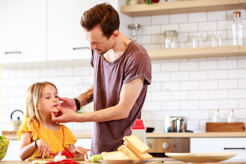 Foto des jungen Vaters mit der Tochter, die lunchn kocht stockfoto Foto des jungen Vaters mit der Tochter, die lunchn kocht stockfoto