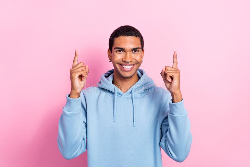 Foto di allegro buon umore allegro sorriso uomo indossare felpa blu hodie dirigere le dita verso l'alto la pubblicità vuota dello fotografia stock libera da diritti