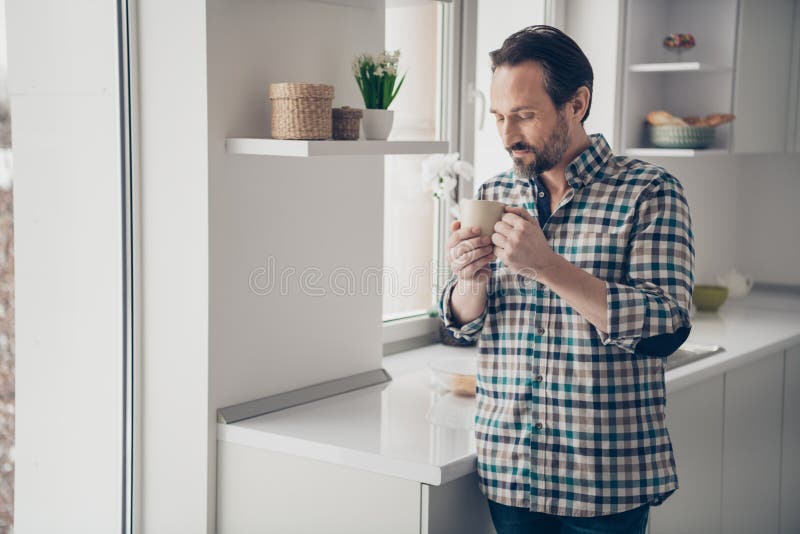 Foto di compiaciuto ottimista riposo bello felice di buon umore di un tizio con una tazza di delizioso caffè in mano immagine stock Foto di compiaciuto ottimista riposo bello felice di buon umore di un tizio con una tazza di delizioso caffè in mano immagine stock