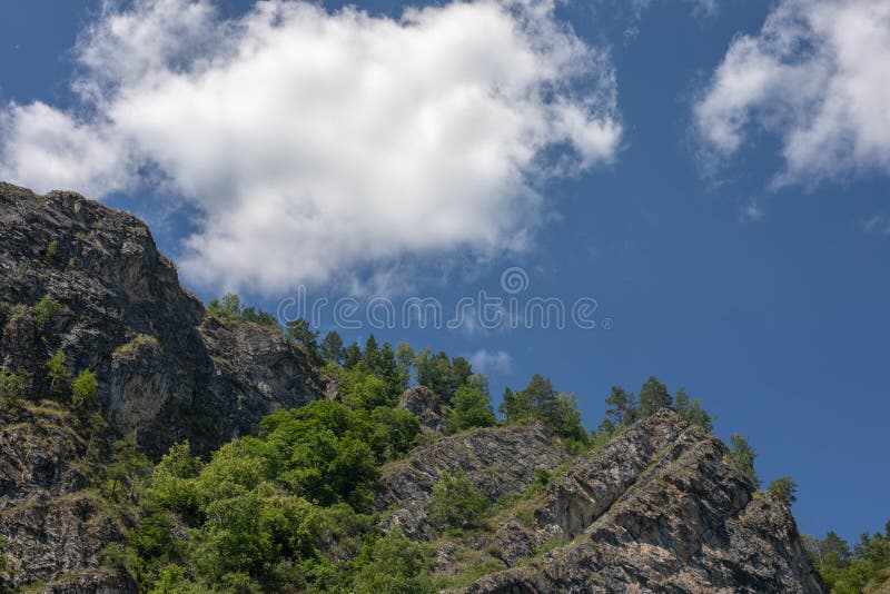 foto di picchi di montagna in una giornata di sole limpida nuvole bianche nel cielo azzurro sullo sfondo fotografia stock libera da diritti foto di picchi di montagna in una giornata di sole limpida nuvole bianche nel cielo azzurro sullo sfondo fotografia stock libera da diritti