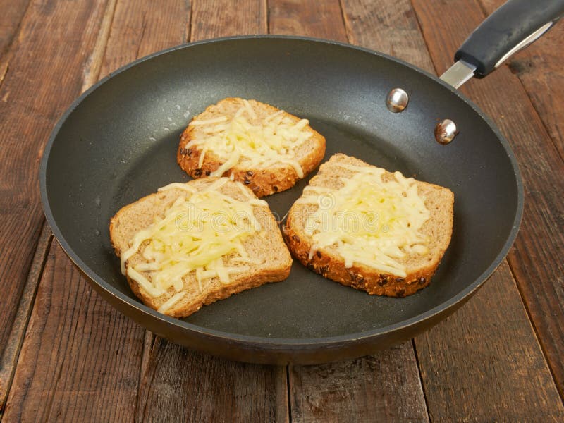 Foto di un panino arrostito del formaggio che cucina in una grande padella fotografia stock Foto di un panino arrostito del formaggio che cucina in una grande padella fotografia stock