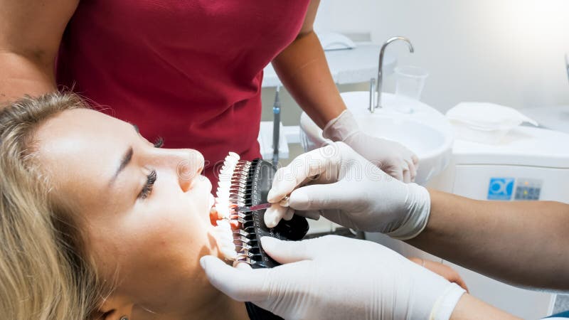 Foto Do Close Up Do Dentista Que Verifica A Cor Paciente Dos Dentes Com