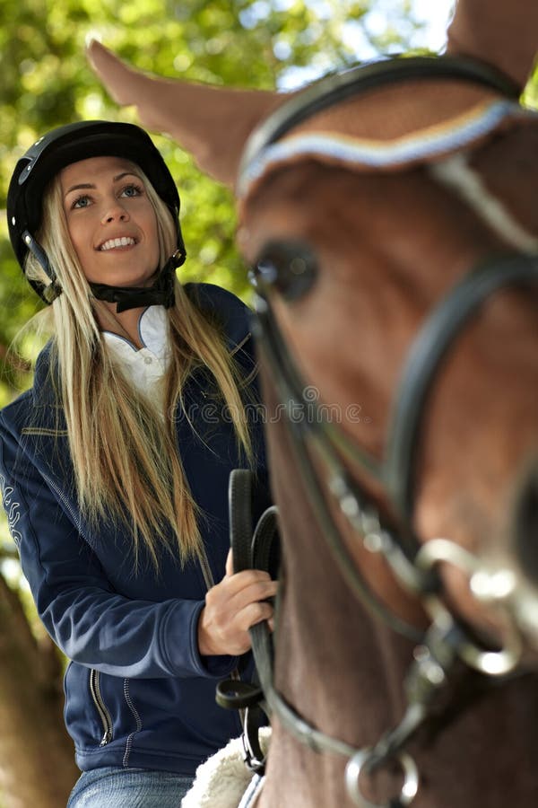 Foto do close up do cavaleiro e do cavalo louros fotografia de stock royalty free