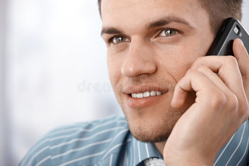 Foto do close up do homem de negócios de sorriso no móbil imagens de stock royalty free