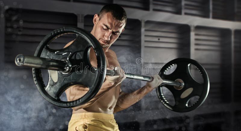 A foto do close up do indivíduo considerável do halterofilista prepara-se para fazer exercícios com barbell em um gym, mantém a p fotos de stock