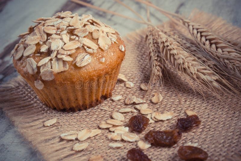 A foto do vintage, queque fresco com farinha de aveia cozeu com farinha do wholemeal e orelhas da grão do centeio, sobremesa saud foto de stock A foto do vintage, queque fresco com farinha de aveia cozeu com farinha do wholemeal e orelhas da grão do centeio, sobremesa saud foto de stock