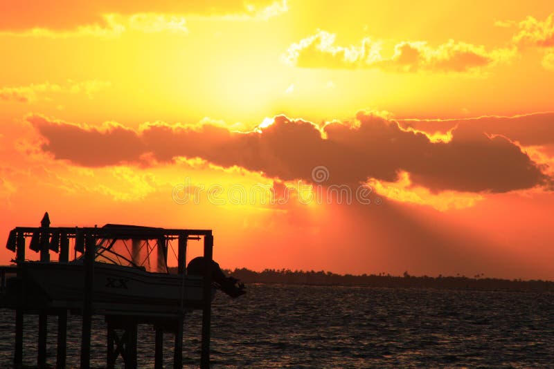 Foto dram?tica de la puesta del sol con la elevaci?n del barco en primero plano imagenes de archivo Foto dram?tica de la puesta del sol con la elevaci?n del barco en primero plano imagenes de archivo
