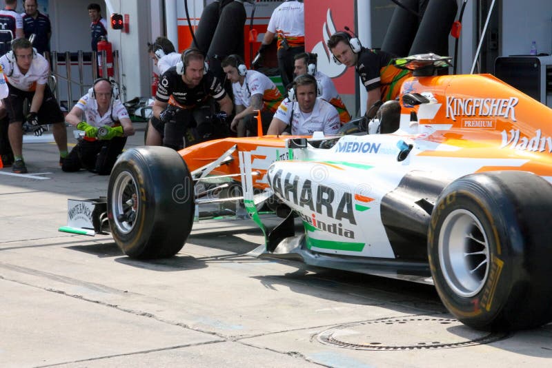 F1 Photo : Formula 1 Force India race car pitstop – team mechanics work in paddock. F1 Photo : Formula 1 Force India race car pitstop – team mechanics work in paddock