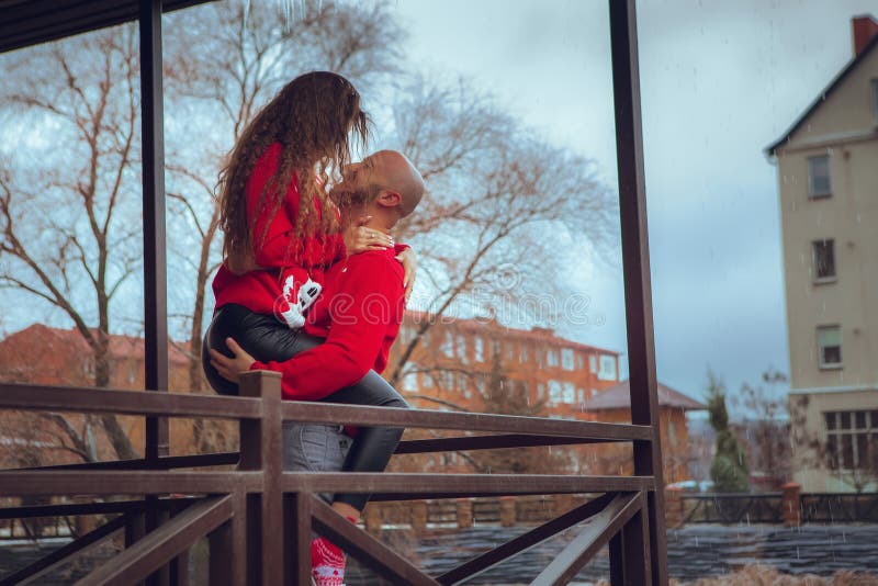 Foto horizontal de apasionados abrazos de pareja en un balcón en invierno. humor navideño fotografía de archivo