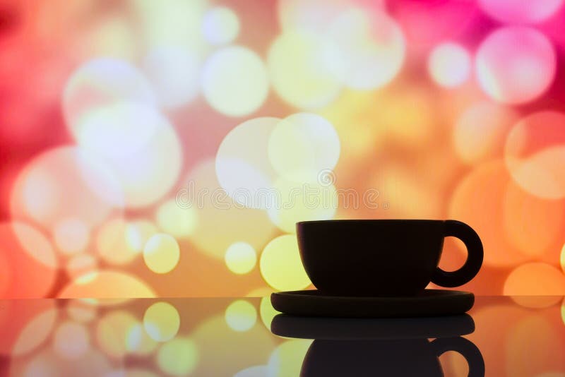 Foto horizontal de la taza de café de la silueta en la parte posterior colorida del bokeh foto de archivo