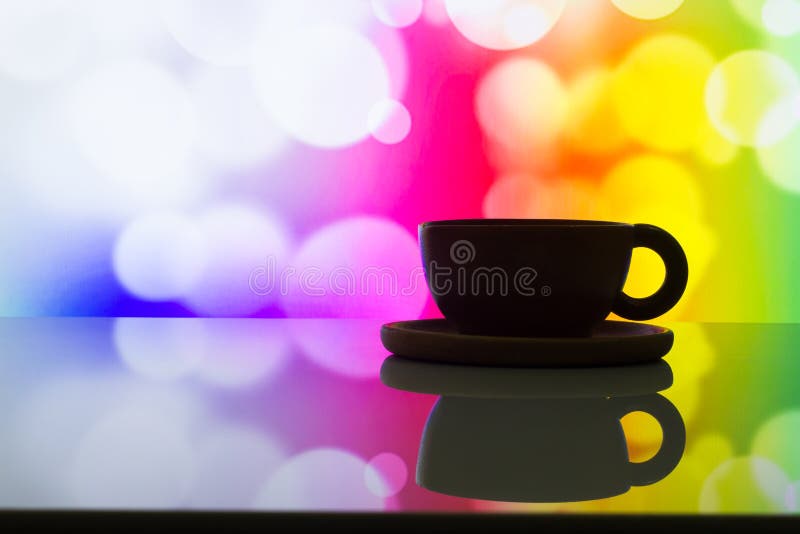 Foto horizontal de la taza de café de la silueta en la parte posterior colorida del bokeh imagen de archivo