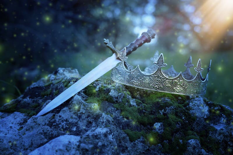 mysterious and magical photo of silver king crown and sword over the stone in the England woods or field landscape with light. mysterious and magical photo of silver king crown and sword over the stone in the England woods or field landscape with light