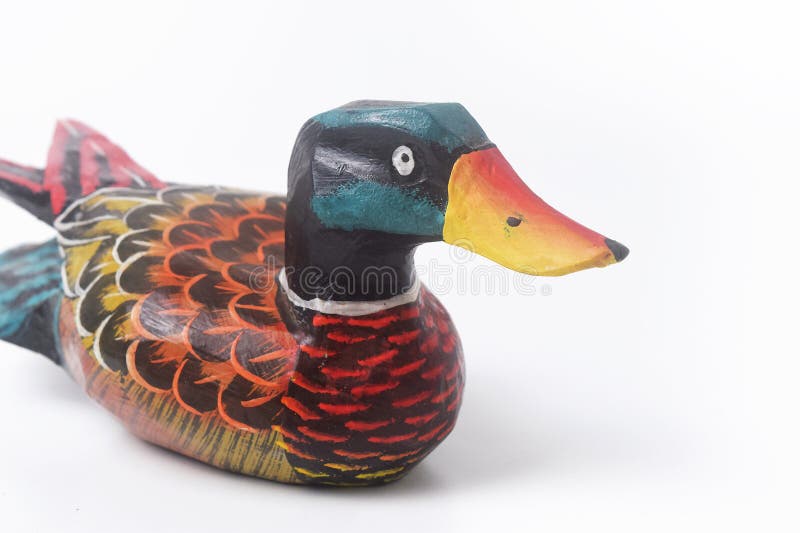 Brebes, Indonesia, June 2, 2023 : Close up photo of a typical Indonesian toy duck made of wood and painted in attractive colors, Isolated White. Brebes, Indonesia, June 2, 2023 : Close up photo of a typical Indonesian toy duck made of wood and painted in attractive colors, Isolated White