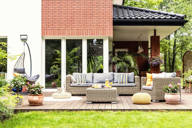 Foto real de una terraza hermosa con los muebles del jardín, plantas