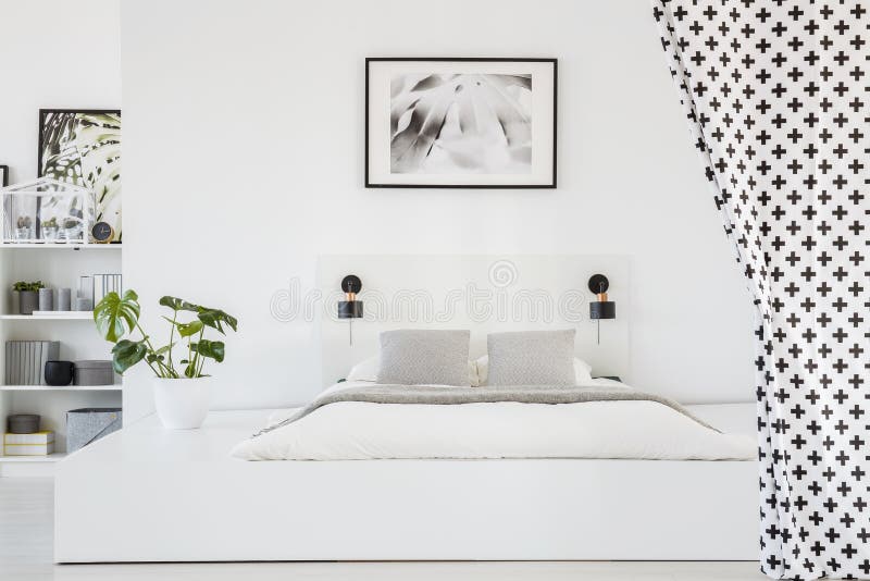 Foto reale di un interno spazioso e bianco della camera da letto con una piattaforma fotografia stock libera da diritti