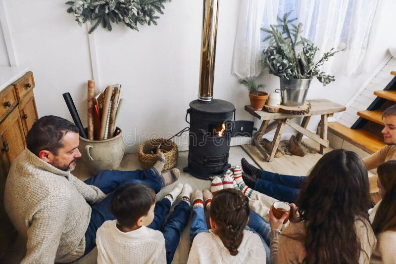 Foto recortada da família grande usando meias de lã quente descansando por lareira fotos de stock