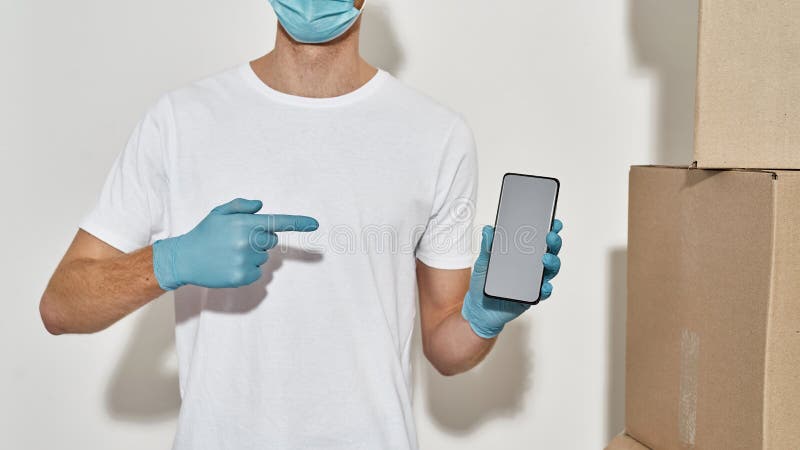 Foto recortada de um jovem entregador apontando no smartphone com aplicativo de entrega fotos de stock royalty free