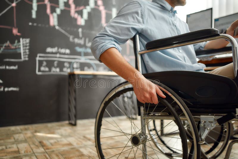 Foto recortada do trabalhador do escritório masculino em uma cadeira de rodas trabalhando no escritório moderno. homem deficiente foto de stock
