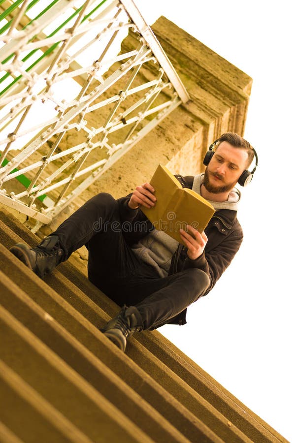 Foto retra del estilo de una sentada y de una lectura del hombre del inconformista imagenes de archivo Foto retra del estilo de una sentada y de una lectura del hombre del inconformista imagenes de archivo