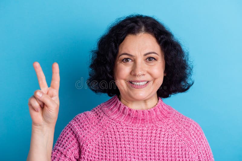 Foto ritratto di una vecchietta felice che mostra due segni isolati su sfondo blu pastel fotografia stock