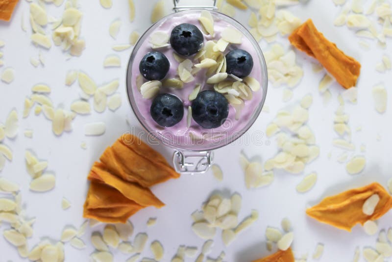 Foto's van hierboven van bosbessenyoghurt met Amerikaanse veenbessen bij bovenkant, amandelen en het droge mango verfraaien stock afbeeldingen Foto's van hierboven van bosbessenyoghurt met Amerikaanse veenbessen bij bovenkant, amandelen en het droge mango verfraaien stock afbeeldingen