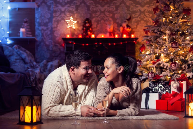 Foto van een mooi jong koppel thuis in de winter om kerstmis te vieren royalty-vrije stock fotografie Foto van een mooi jong koppel thuis in de winter om kerstmis te vieren royalty-vrije stock fotografie