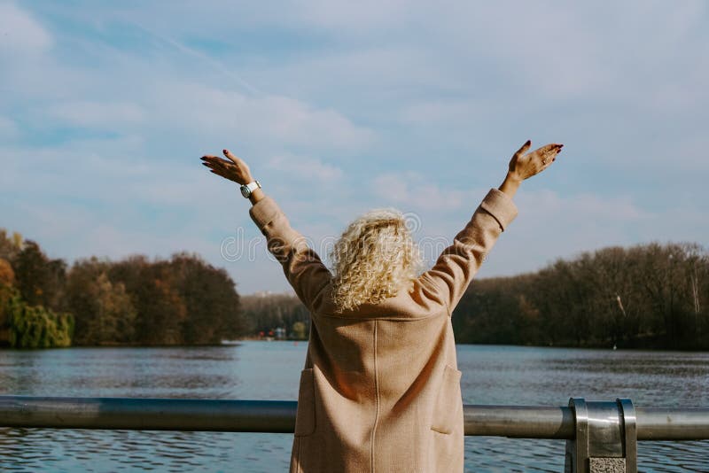 Foto van een mooie blondy vrouw met armen in de natuur tijdens de herfstdag stock afbeeldingen Foto van een mooie blondy vrouw met armen in de natuur tijdens de herfstdag stock afbeeldingen