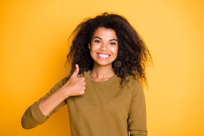 Photo of cheerful positive cute nice charming pretty black skinned, girlfriend showing you thumb up demonstrating good quality and teeth isolated over vivid color background. Photo of cheerful positive cute nice charming pretty black skinned, girlfriend showing you thumb up demonstrating good quality and teeth isolated over vivid color background