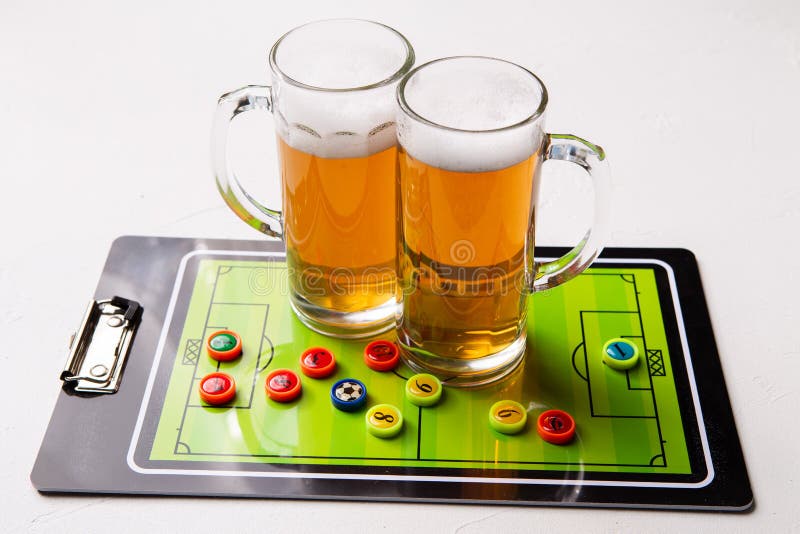 Foto van twee mokken schuimend bier, lijstvoetbal stock foto Foto van twee mokken schuimend bier, lijstvoetbal stock foto
