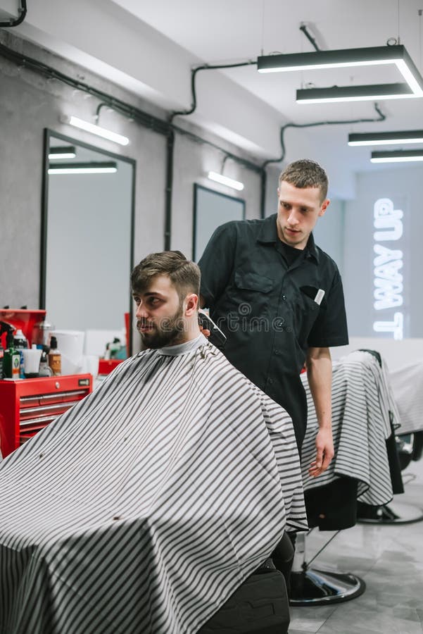 Apuesto Peluquero O Utiliza La Barba Corta Barba Hombre Con El Cliente De  Corte De Teléfono No Se Sienta En Silla En Barbería O Salón De Peluquería  Fotos, retratos, imágenes y fotografía