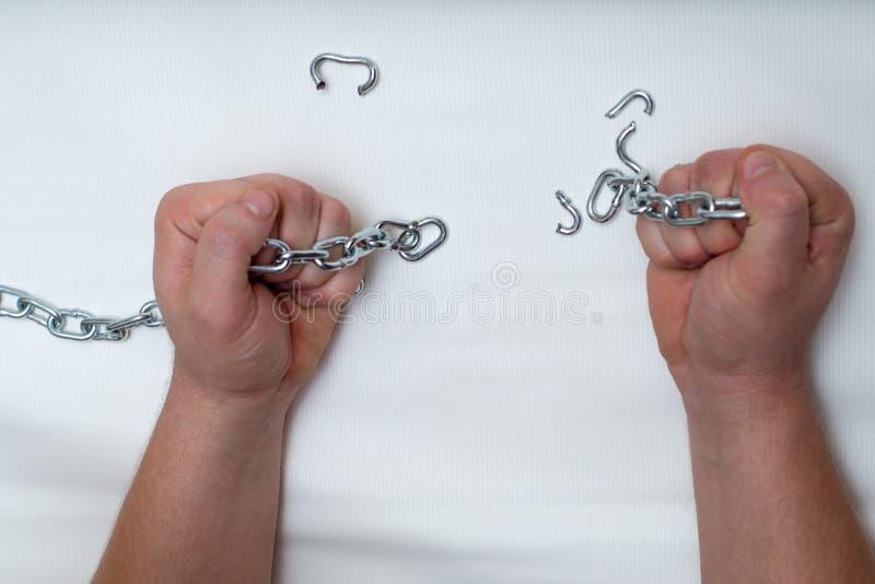 Photo of hands holding a broken mettalic chain. Photo of hands holding a broken mettalic chain