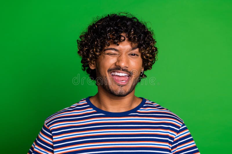 Photo of funky crazy nice man wear trendy striped clothes wink blink isolated on green color background. Photo of funky crazy nice man wear trendy striped clothes wink blink isolated on green color background.
