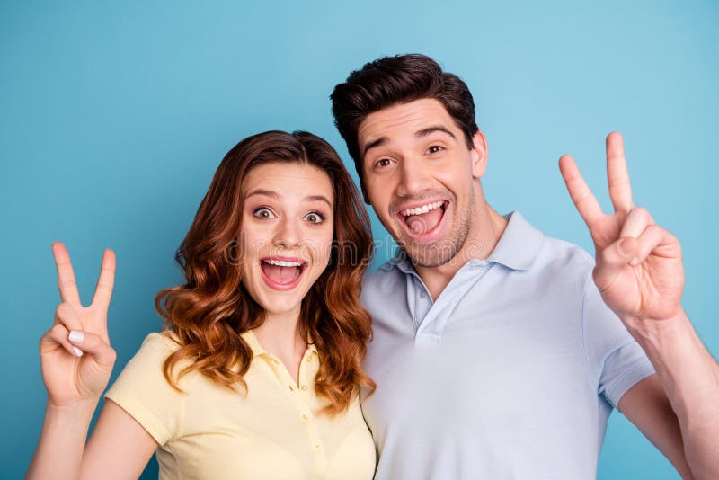 Foto von Vzeichen-Symbolhänden der lustigen Paare aufgeregten, die positive nette Sagenhallo Freunde zufällige T-Shirts tragen, l stockfoto Foto von Vzeichen-Symbolhänden der lustigen Paare aufgeregten, die positive nette Sagenhallo Freunde zufällige T-Shirts tragen, l stockfoto