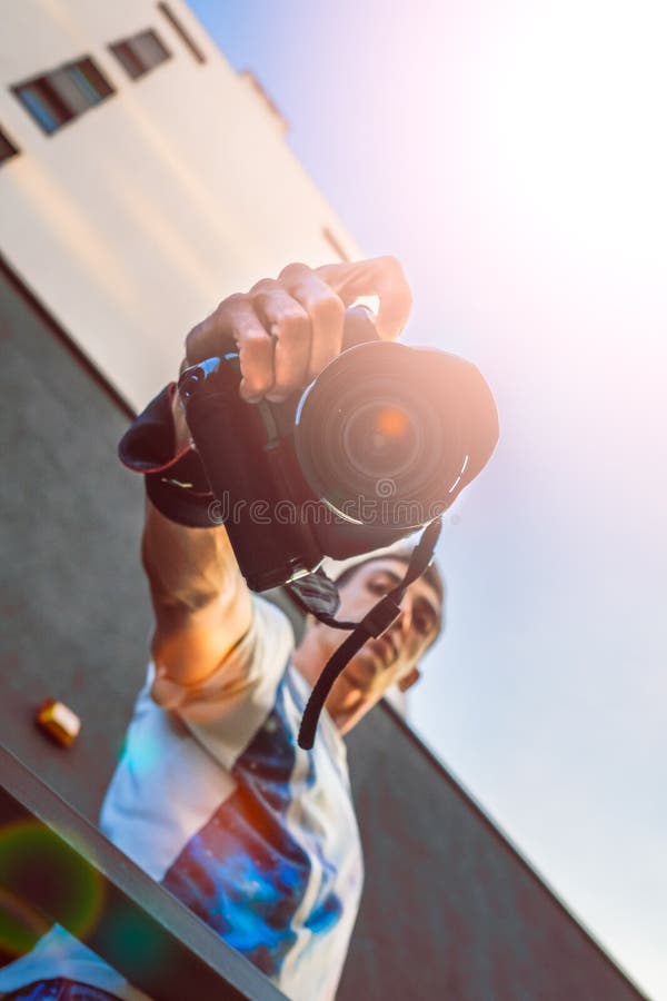 Fotoet för solsignalljussolnedgången av det manliga turist- eller fotografdanandefotoet på parallell kamera för tappninghipsterfi arkivbilder Fotoet för solsignalljussolnedgången av det manliga turist- eller fotografdanandefotoet på parallell kamera för tappninghipsterfi arkivbilder