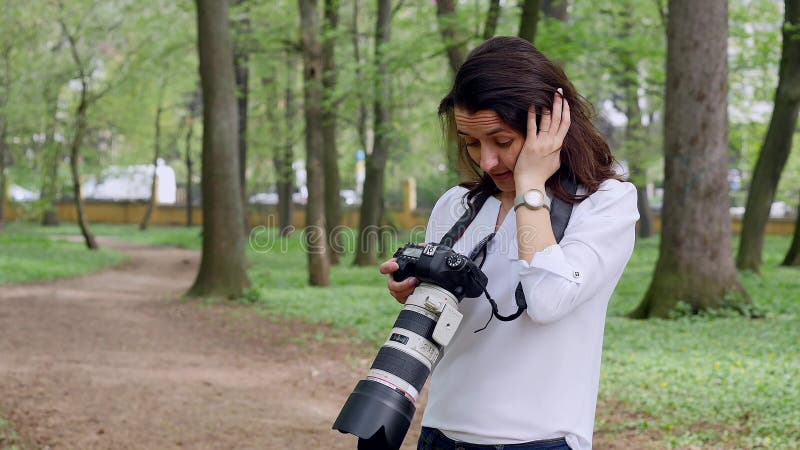 Fotograf der jungen Frau, der draußen Prozeßschießen in der Parknatur bearbeitet
