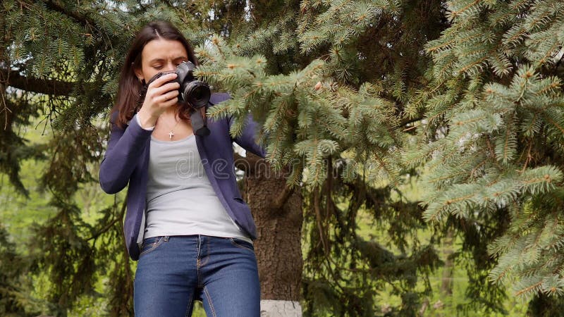 Fotograf der jungen Frau, der draußen Prozeßschießen in der Parknatur bearbeitet