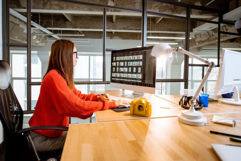 Fotograf, der mit Computer im Büro arbeitet stockbild Fotograf, der mit Computer im Büro arbeitet stockbild