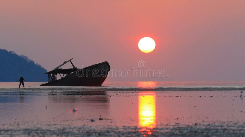 Fotografia do fotógrafo um barco da destruição com fundo de aumentação do céu do sol