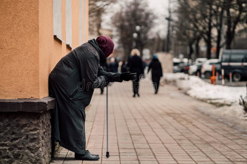 Fotografia stary głodny bezdomny żeński żebrak błaga dla datków i na ulicie obrazy stock Fotografia stary głodny bezdomny żeński żebrak błaga dla datków i na ulicie obrazy stock