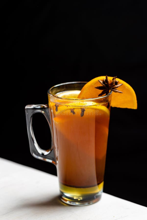 A vertical shot of a glass of Hot toddy cocktail on black background. A vertical shot of a glass of Hot toddy cocktail on black background