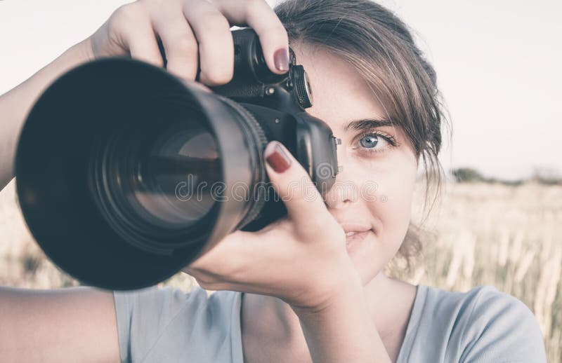 Fotografii twarz młoda kobieta z fotograficznym wyposażeniem w śródpolnym działaniu dla jej przyjemności fotografia royalty free Fotografii twarz młoda kobieta z fotograficznym wyposażeniem w śródpolnym działaniu dla jej przyjemności fotografia royalty free