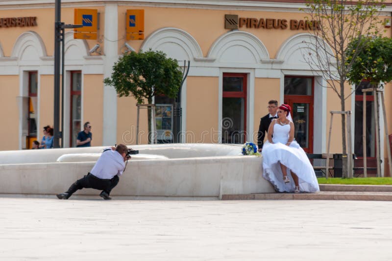 Oradea, Romania - July 30, 2016: Photographer taking a photo of the bride and groom. Oradea, Romania - July 30, 2016: Photographer taking a photo of the bride and groom