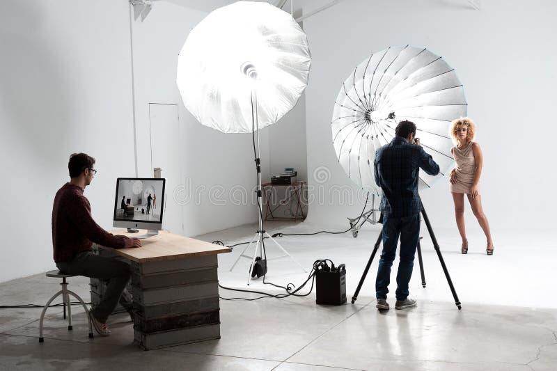 Fotografo che lavora con un modello sveglio in uno studio professionale fotografia stock Fotografo che lavora con un modello sveglio in uno studio professionale fotografia stock
