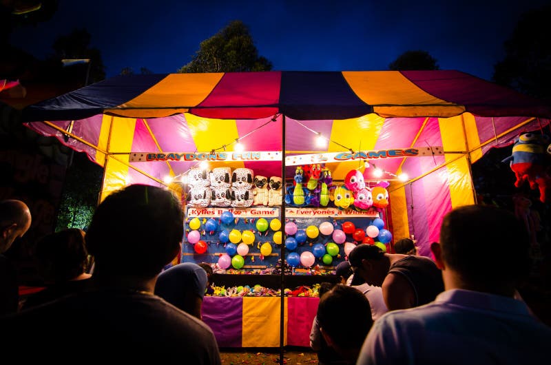 Fotografía de la noche de los premios que ganan de la cabina colorida del juego para las muñecas en la feria de diversión de la c fotografía de archivo Fotografía de la noche de los premios que ganan de la cabina colorida del juego para las muñecas en la feria de diversión de la c fotografía de archivo