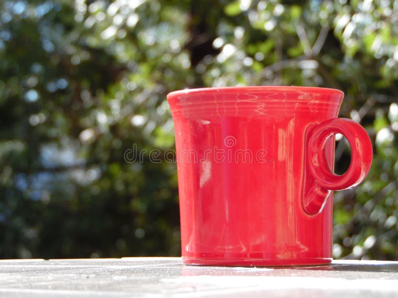 Fotografía de la taza de café roja afuera foto de archivo Fotografía de la taza de café roja afuera foto de archivo